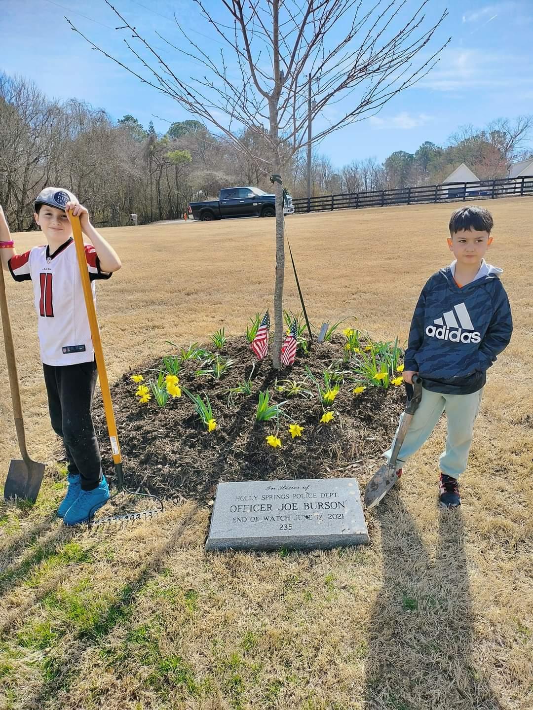Bronson (L) and Ezra (R) standing next to the memorial after a weekend of planting. (Courtesy of Kristina Chancer)