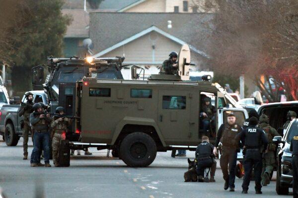 Law enforcement officers aim their weapons at a home during a standoff in Grants Pass, Ore., on Jan. 31, 2023. (Scott Stoddard/Grants Pass Daily Courier via AP)