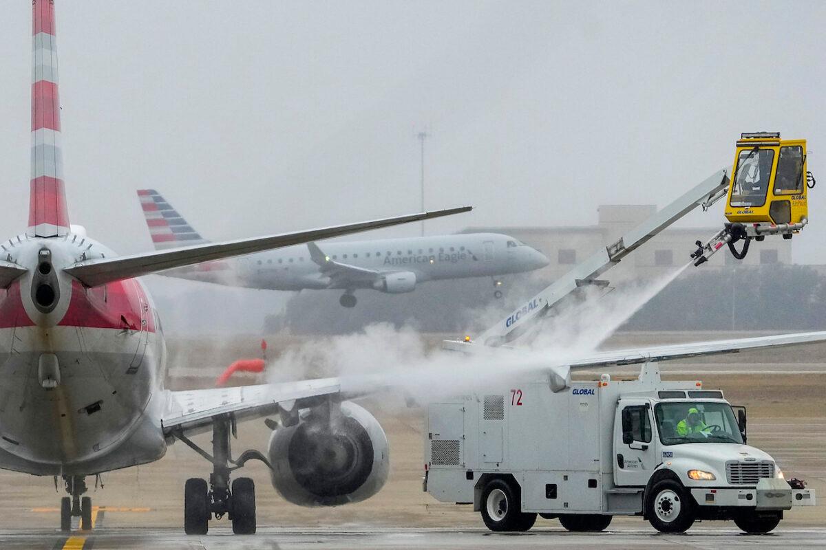 An American Airlines aircraft undergoes de-icing procedures at Dallas-Fort Worth International Airport in Texas on Jan. 30, 2023. (Lola Gomez/The Dallas Morning News via AP)