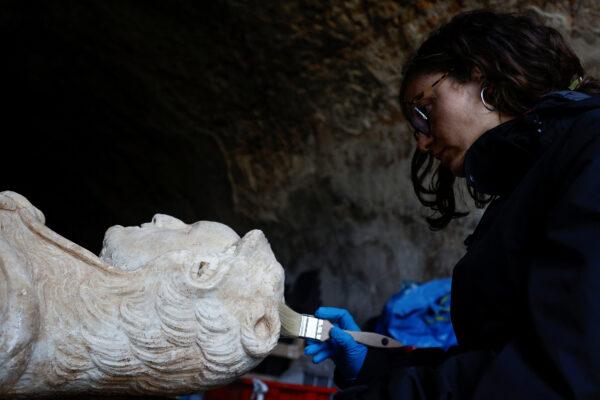 Restorer from Appia Antica archaeological park Sara Iovine cleans a life-sized statue of a Roman emperor posing as the classical hero Hercules after it was discovered during sewer repair works near the old Appian Way, ancient Rome's first highway in Rome on Feb. 1, 2023. (Guglielmo Mangiapane/Reuters)