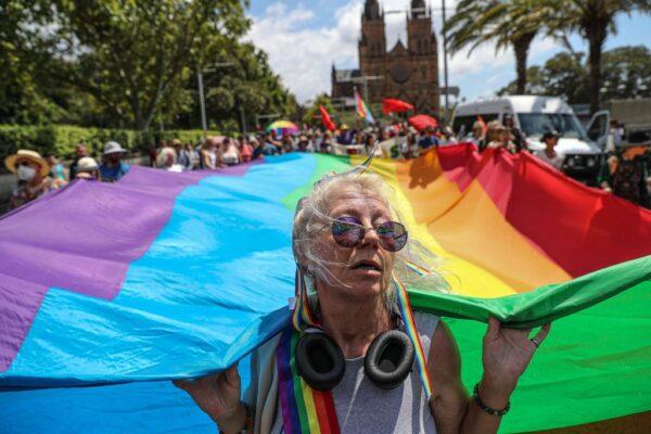 Protesters hold a giant rainbow flag outside St Mary's Cathedral ahead of the pontifical requiem Mass for Cardinal George Pell on February 02, 2023 in Sydney, Australia. (Photo by Roni Bintang/Getty Images)