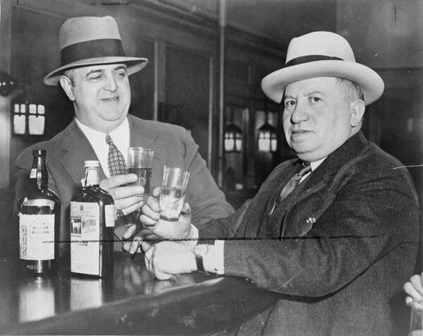 Izzy Einstein (R) and Moe Clark, former police officers during Prohibition, sharing a toast in a New York bar, 1935. (Public Domain)