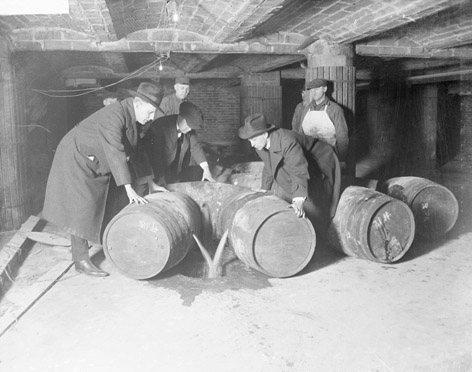 Prohibition agents destroying barrels of alcohol, circa 1921. (Public Domain)