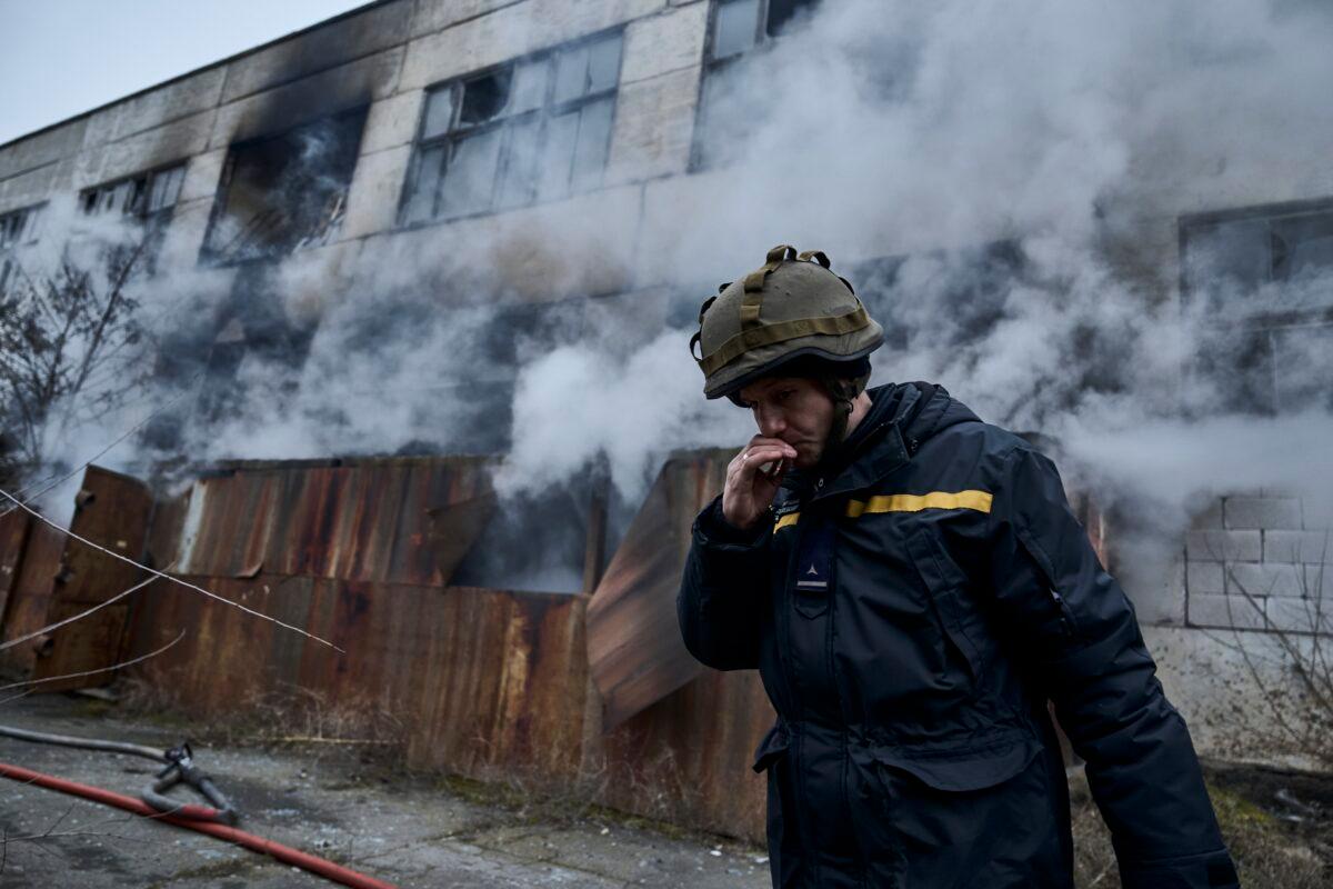 A Ukrainian State Emergency Service firefighter smokes as he takes a break following Russian shelling that hit an industrial area in Kherson, Ukraine, on Feb. 5, 2023. (Libkos/AP Photo)