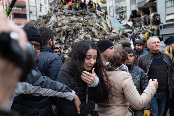 A woman reacts as rescuers search for survivors through the rubble of collapsed buildings in Adana on Feb. 6, 2023. (Can Erok/AFP via Getty Images)