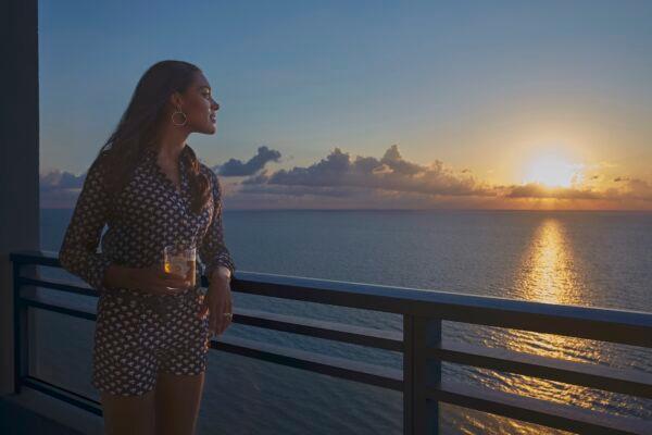 A guest enjoys the sunrise over the Atlantic Ocean from her hotel room balcony at the Diplomat Beach Resort. (Courtesy of the Diplomat Beach Resort)