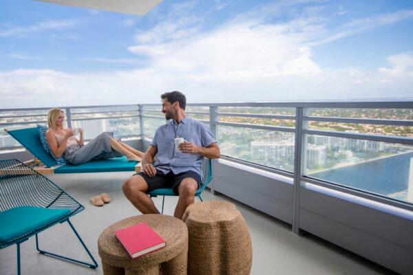 A couple enjoys relaxing on their corner suite balcony with views of both the Atlantic Ocean and the Intercoastal. (Courtesy of the Diplomat Beach Resort)