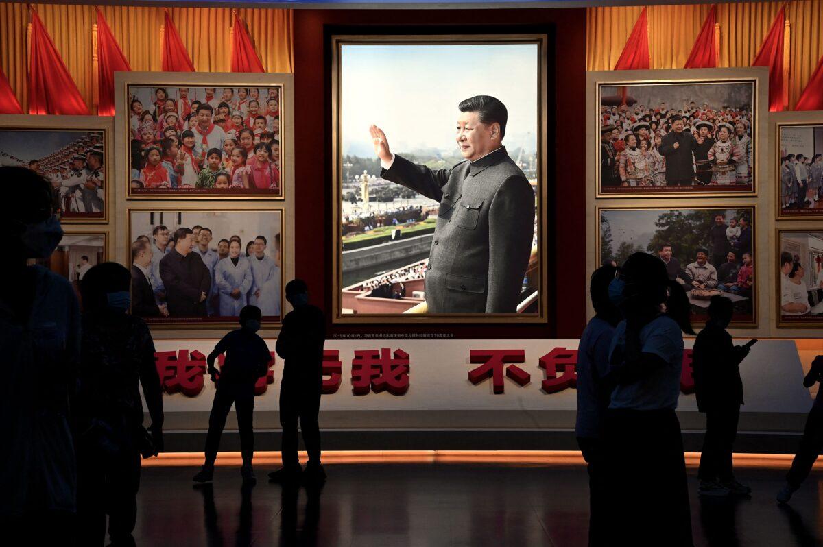People stand in front of images of Chinese leader Xi Jinping at the Museum of the Communist Party of China in Beijing on Sept. 4, 2022. (Noel Celis/AFP via Getty Images)
