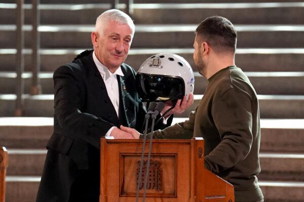 Speaker of the House of Commons, Sir Lindsay Hoyle (left), holds the helmet of one of the most successful Ukrainian pilots, inscribed with the words, "We have freedom, give us wings to protect it," which was presented to him by Ukrainian President Volodymyr Zelenskyy as he addressed parliamentarians in Westminster Hall, London, on Feb. 8, 2023. (Stefan Rousseau/PA Media)