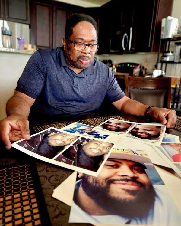 Antonio Harrison looks over pictures of his son, Drew, on Feb. 2, 2023. (Allan Stein/The Epoch Times)