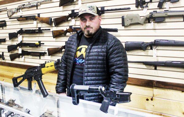 Justin Barrett, owner of Barrett Outdoors in Durant, Okla., displays some pistol stabilizing braces. (Michael Clements/The Epoch Times)