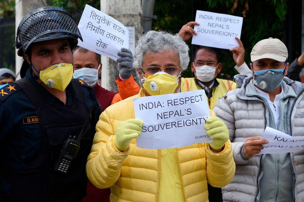 Human rights activists hold placards during a protest against India's newly inaugurated link road to the Chinese border, near Indian embassy in Kathmandu on May 12, 2020. - Nepal protested India's inauguration of a new road to China that passes through territory claimed by Kathmandu on May 9, with police detaining dozens of demonstrators. (Prakash Mathema/AFP via Getty Images)