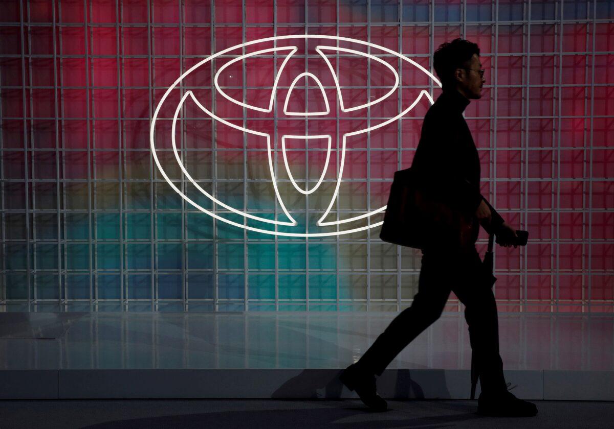 A man walks past a Toyota logo at the Tokyo Motor Show on Oct. 24, 2019. (Edgar Su/Reuters)