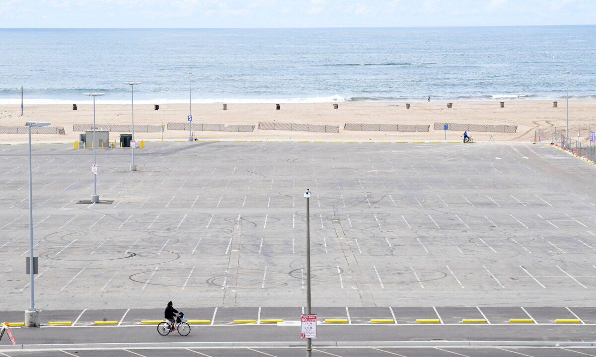 Social distance: A cyclist rides past a Santa Monica beach parking lot in Santa Monica, Calif., on March 24, 2020. (Frederic J. Brown/AFP via Getty Images)
