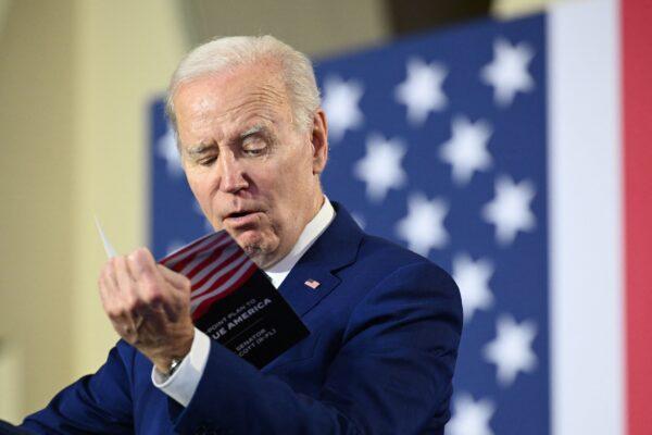 President Joe Biden reads from a pamphlet by Sen. Rick Scott (R-Fla.) while delivering remarks on his plan to protect and strengthen Social Security and Medicare, as well as to cut health care costs, at the University of Tampa in Tampa, Fla., on Feb. 9, 2023. (Mandel Ngan/AFP via Getty Images)