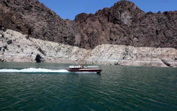 Boaters cruise in front of mineral-stained rocks in The Narrows upstream of the Hoover Dam in the Lake Mead National Recreation Area, Nev., on July 28, 2022. (Ethan Miller/Getty Images)