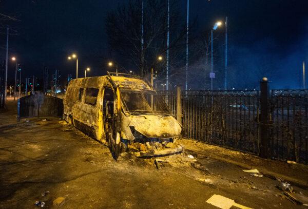 A burnt-out police van after a demonstration outside the Suites Hotel in Knowsley, Merseyside, England on Feb. 10, 2023. (Peter Powell/PA Media)