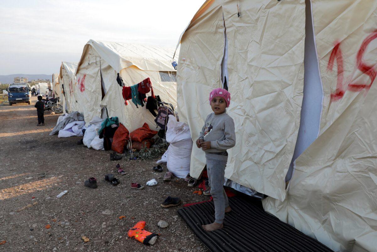 A child stands outside tents erected for people affected by a devastating earthquake in rebel-held town of Jandaris, Syria, on Feb. 11, 2023. (Mahmoud Hassano/Reuters)