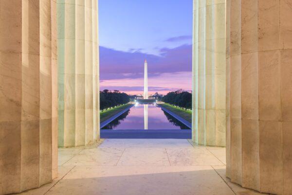 A view from the side of the memorial of the National Mall with the reflection pond, the George Washington monument and Capitol building in the background. (/Shutterstock)