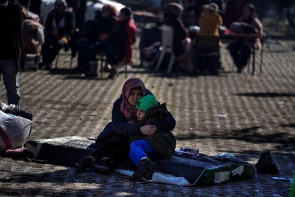 A woman hugs her son as they and others sit in a public garden in Adiyaman, southern Turkey, on Feb. 12, 2023. (Khalil Hamra/AP Photo)