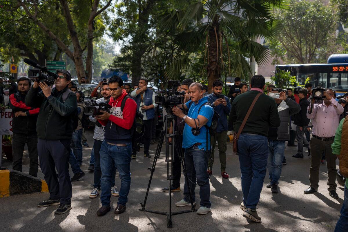 Media personnel report standing outside a building housing a BBC office in New Delhi on Feb. 14, 2023. (Altaf Qadri/AP Photo)