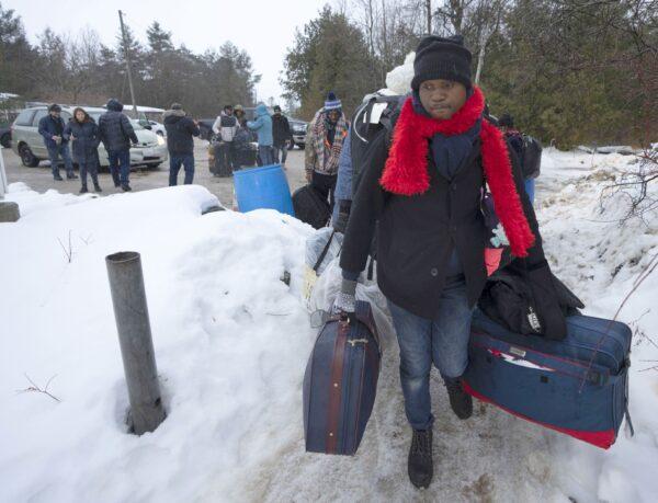 Asylum seekers from Congo cross the border at Roxham Road in Quebec from Champlain, New York, on Feb. 9, 2023. (The Canadian Press/Ryan Remiorz)