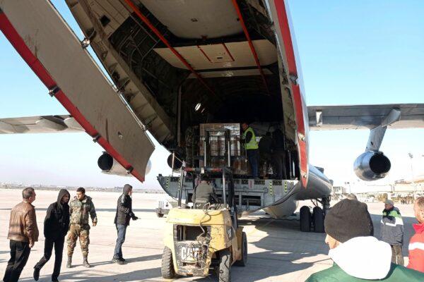 Workers unload humanitarian aid sent from Saudi Arabia for Syria following a devastating earthquake, at the airport in Aleppo, Syria, on Feb. 14, 2023. (SANA via AP)
