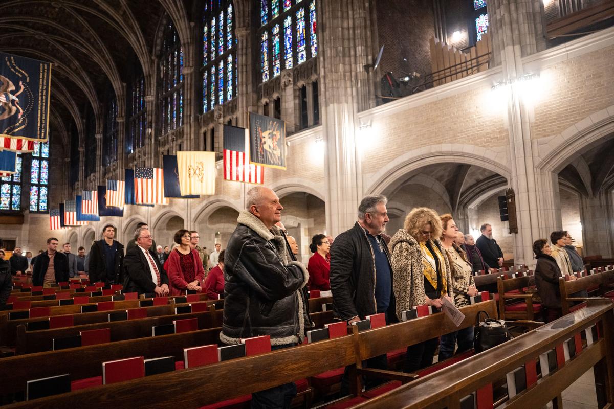Audience members at Salvatore Pronestì's organ recital stand for "The Star-Spangled Banner" at the Cadet Chapel at West Point, N.Y., on Feb. 12, 2023. (Samira Bouaou/The Epoch Times)