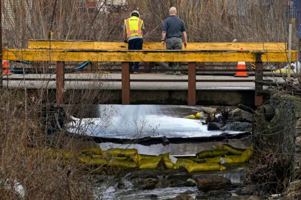 HEPACO workers, an environmental and emergency services company, observe a stream in East Palestine, Ohio, on Feb. 9, 2023, as the cleanup continues after the derailment of a Norfolk Southern freight train. (Gene J. Puskar/AP Photo)