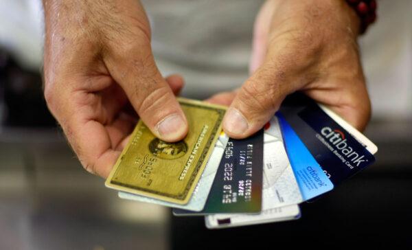 A man shows off some of his credit cards as he pays for items at Lorenzo's Italian Market in Miami, Fla., on May 20, 2009. (Joe Raedle/Getty Images)