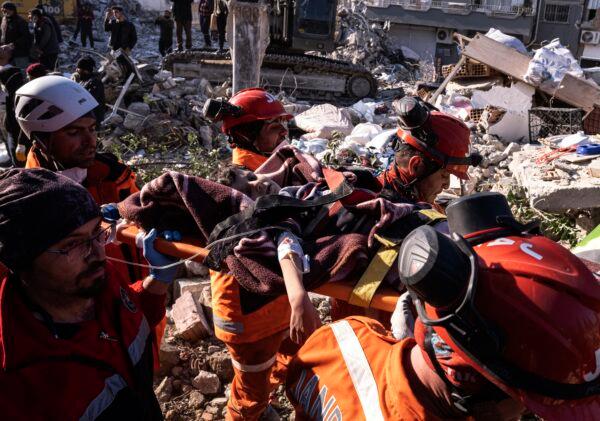 Rescue workers and medics pull out a person from a collapsed building in Antakya, Turkey, on Feb. 15, 2023. (Ugur Yildirim/DIA via AP)