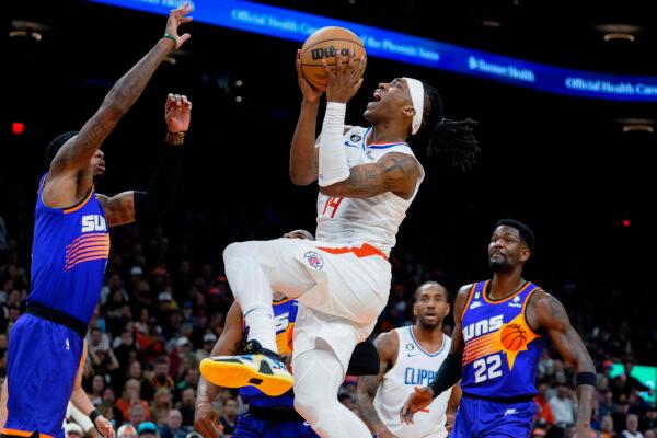 Los Angeles Clippers' Terance Mann (14) drives to the basket between Phoenix Suns' Torrey Craig, left, and Deandre Ayton during the first half of an NBA basketball game on Feb. 16, 2023. (Darryl Webb/AP Photo)