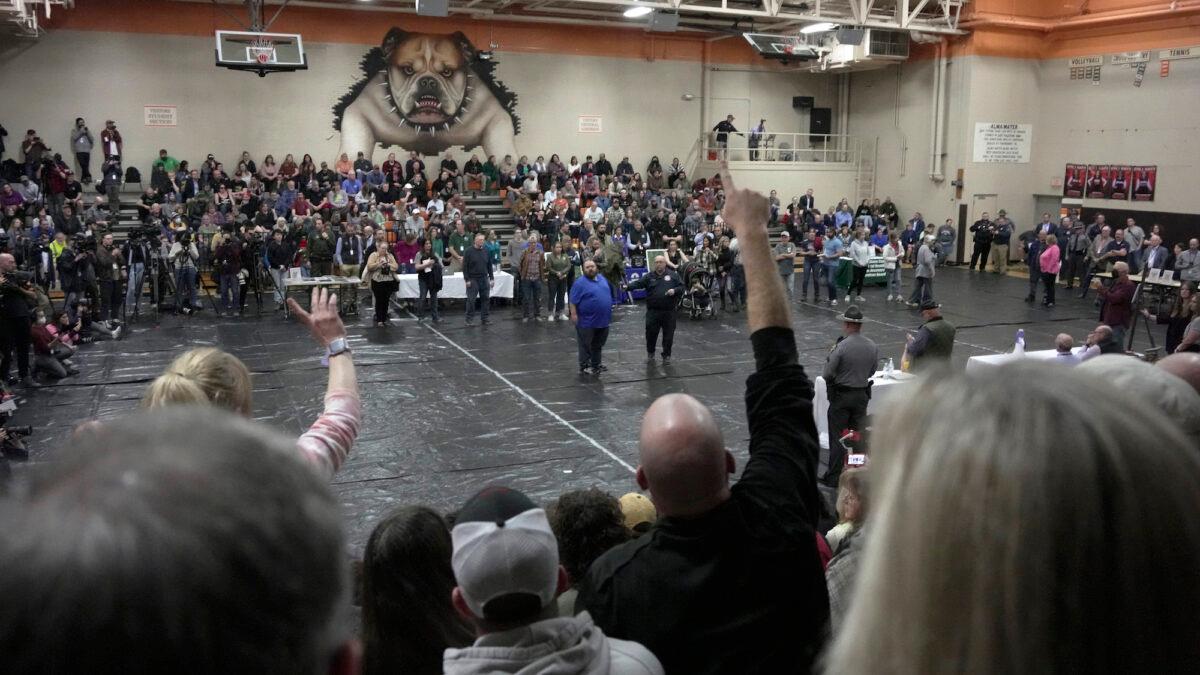 A man raises his hand with a question for East Palestine Mayor Trent Conaway, center, during a town hall meeting at East Palestine High School in East Palestine, Ohio, Wednesday, Feb. 15, 2023. (Gene J. Puskar/AP Photo)