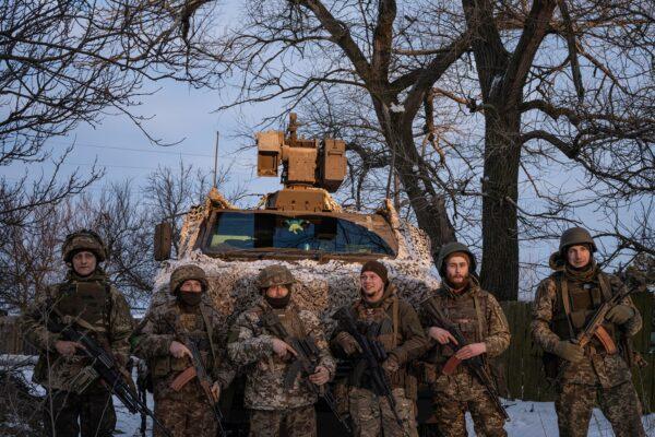 Ukrainian servicemen of the 80th Air Assault Brigade stand in front of a Bushmaster Protected Mobility Vehicle near Bahmut, Donetsk region, Ukraine, on Feb. 16, 2023. (Marko Djurica/Reuters)