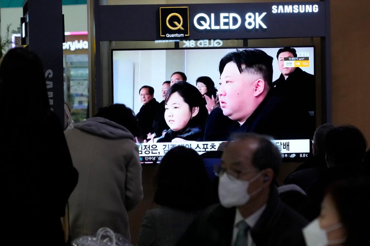 A TV screen shows a file image of North Korean leader Kim Jong Un (R) and his daughter, reportedly named Kim Ju Ae, during a news program at the Seoul Railway Station in Seoul, South Korea, on Feb. 18. 2023. (Ahn Young-joon/AP Photo)
