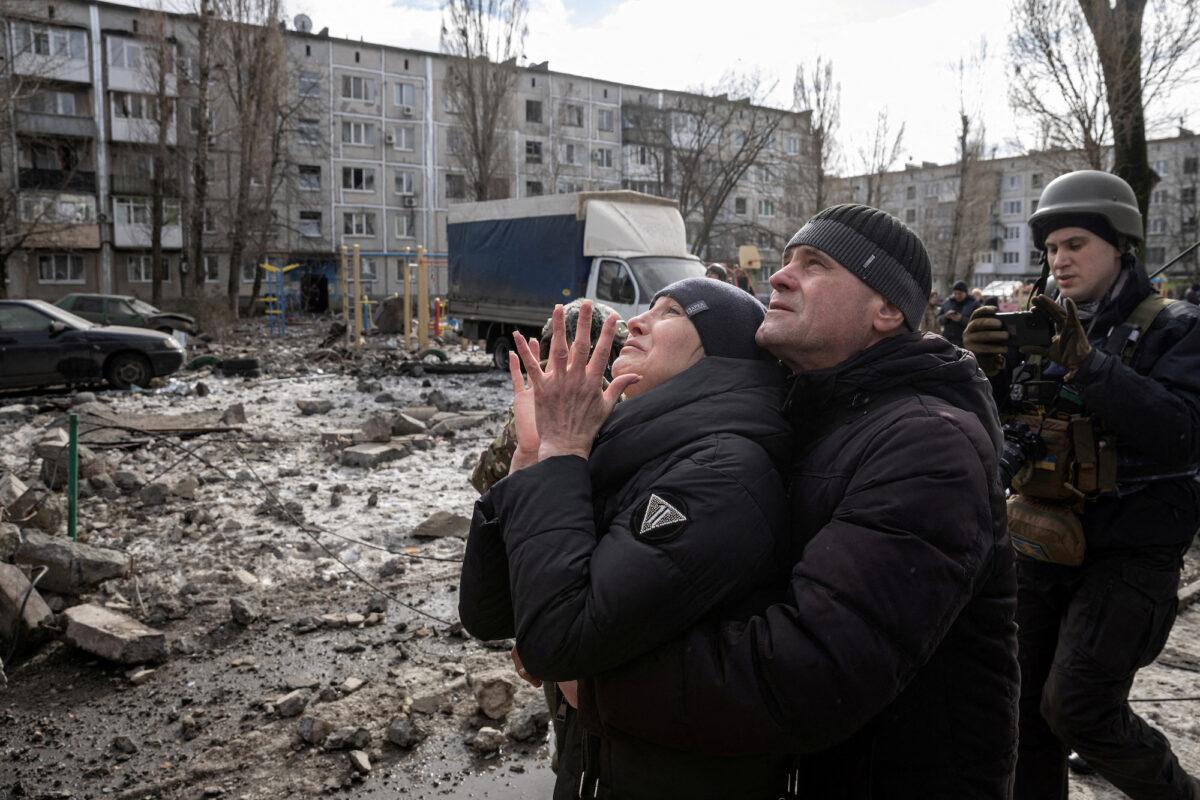 A woman reacts as her brother is rescued after an apartment building that was heavily damaged by a missile strike, amid the war in Ukraine, in Pokrovsk, Ukraine, on Feb. 15, 2023. (Marko Djurica/Reuters)
