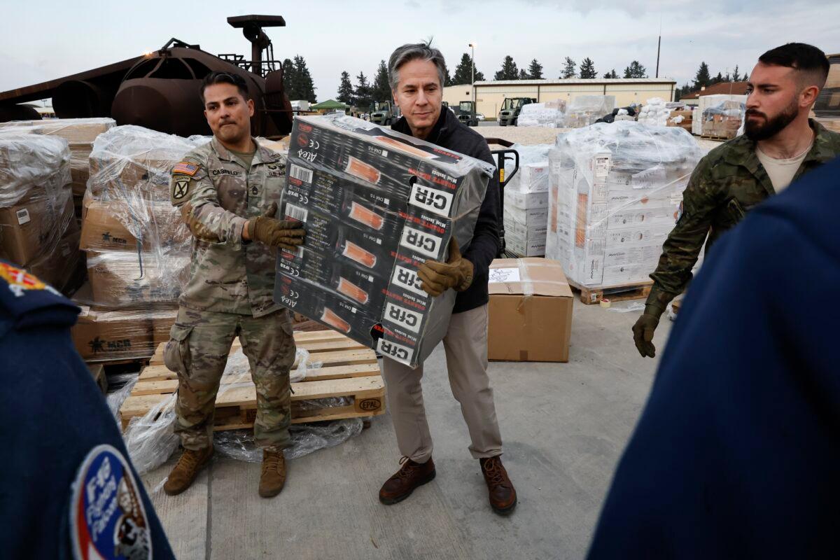 U.S. Secretary of State Antony Blinken (C) helps U.S. military personnel carry aid at Incirlik Air Base near Adana, Turkey, on Feb. 19, 2023. (Clodagh Kilcoyne/Pool Photo via AP)