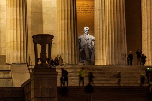 As Lincoln's statue looks out, children play on the stairs of the memorial and adults take leisurely walks on the mall, enjoying the opportunities available to them in the land of the free. (J.H.Smith/Cartiophotos)