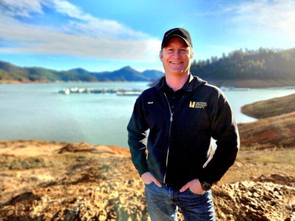 Lake Shasta Caverns General Manager Matt Doyle stands in front of a dry area of Lake Shasta on Feb. 14, 2023. (Allan Stein/The Epoch Times)