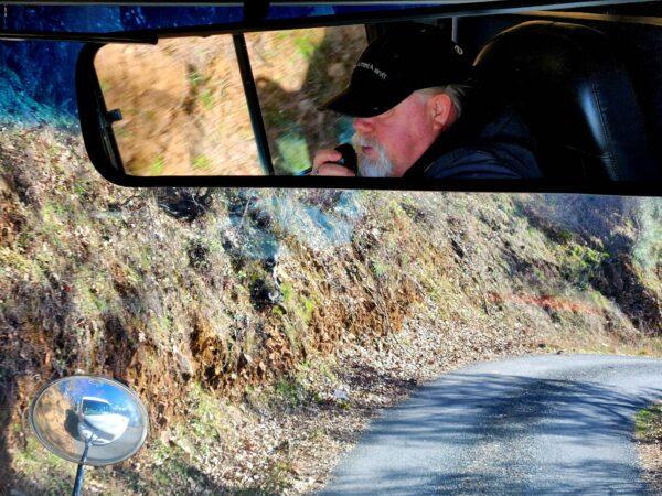 Tour bus driver Tim Lehman shares historical details of Lake Shasta Caverns while driving up the steep winding dirt road on Feb. 14, 2023. (Allan Stein/The Epoch Times)