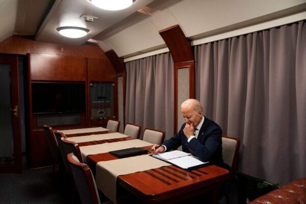 U.S. President Joe Biden sits on a train as he goes over his speech marking the first anniversary of the war in Ukraine after a surprise visit to meet with Ukrainian President Volodymyr Zelenskyy in Kyiv on Feb. 20, 2023. (EVAN VUCCI/POOL/AFP via Getty Images)