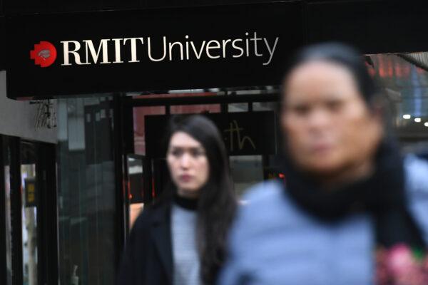 People walk past signage for RMIT university in Melbourne, Australia, on June 10, 2020. (William West/AFP via Getty Images)