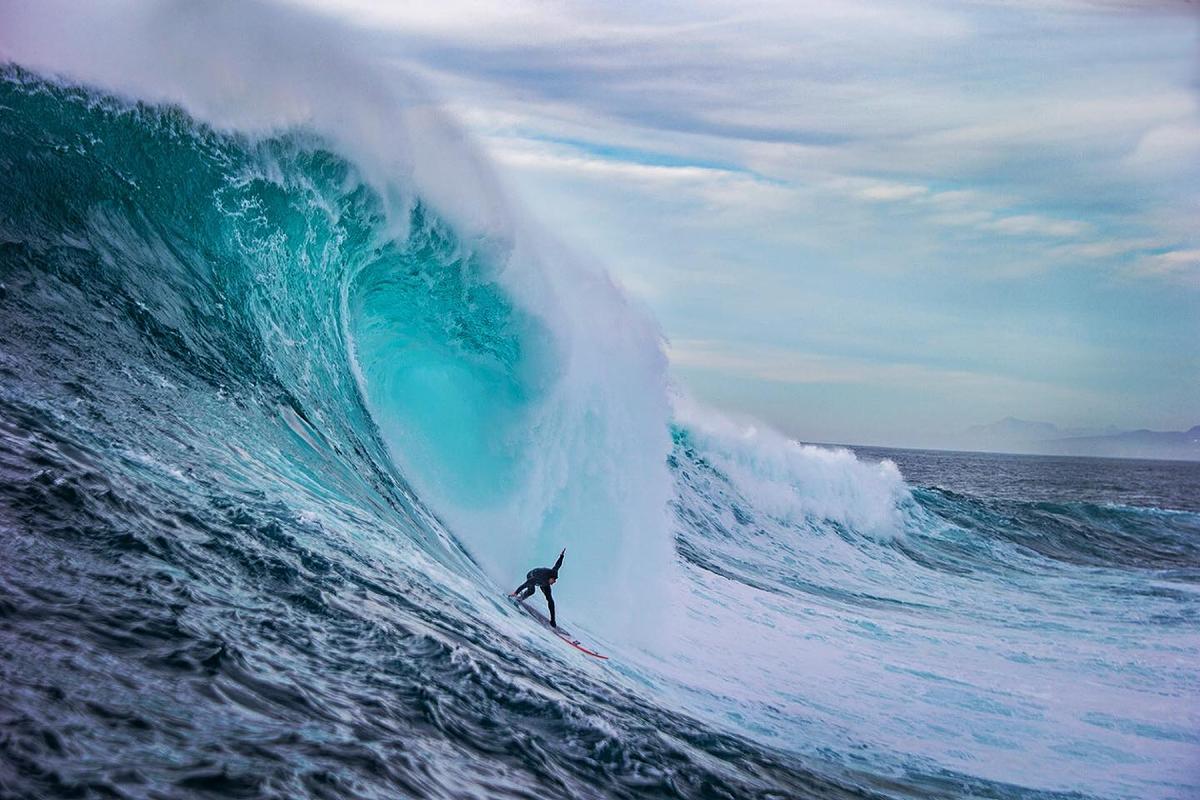 A surfer glides down a big wave. (Courtesy of <a href="https://www.instagram.com/fred_pompermayer/">Fred Pompermayer</a>)