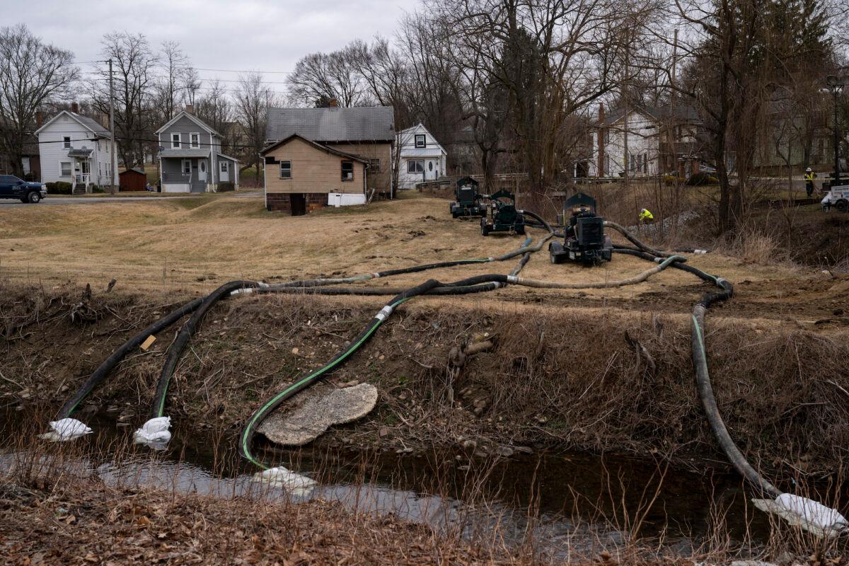 A cleanup crew works alongside a stream as cleanup efforts continue in East Palestine, Ohio, on Feb. 16, 2023. On Feb. 3, a Norfolk Southern train carrying toxic chemicals derailed, causing an environmental disaster. (Michael Swensen/Getty Images)