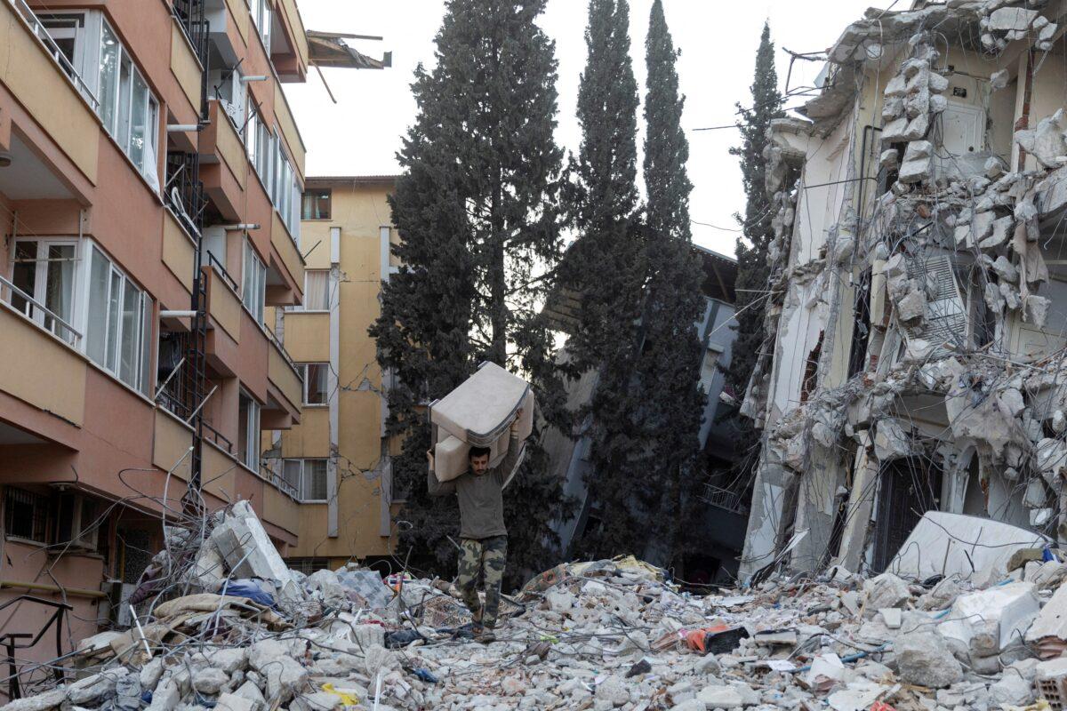 A man carries a sofa out of a destroyed apartment building in the aftermath of the deadly earthquake in Antakya, Hatay province, Turkey, on Feb. 20, 2023. (Eloisa Lopez/Reuters)
