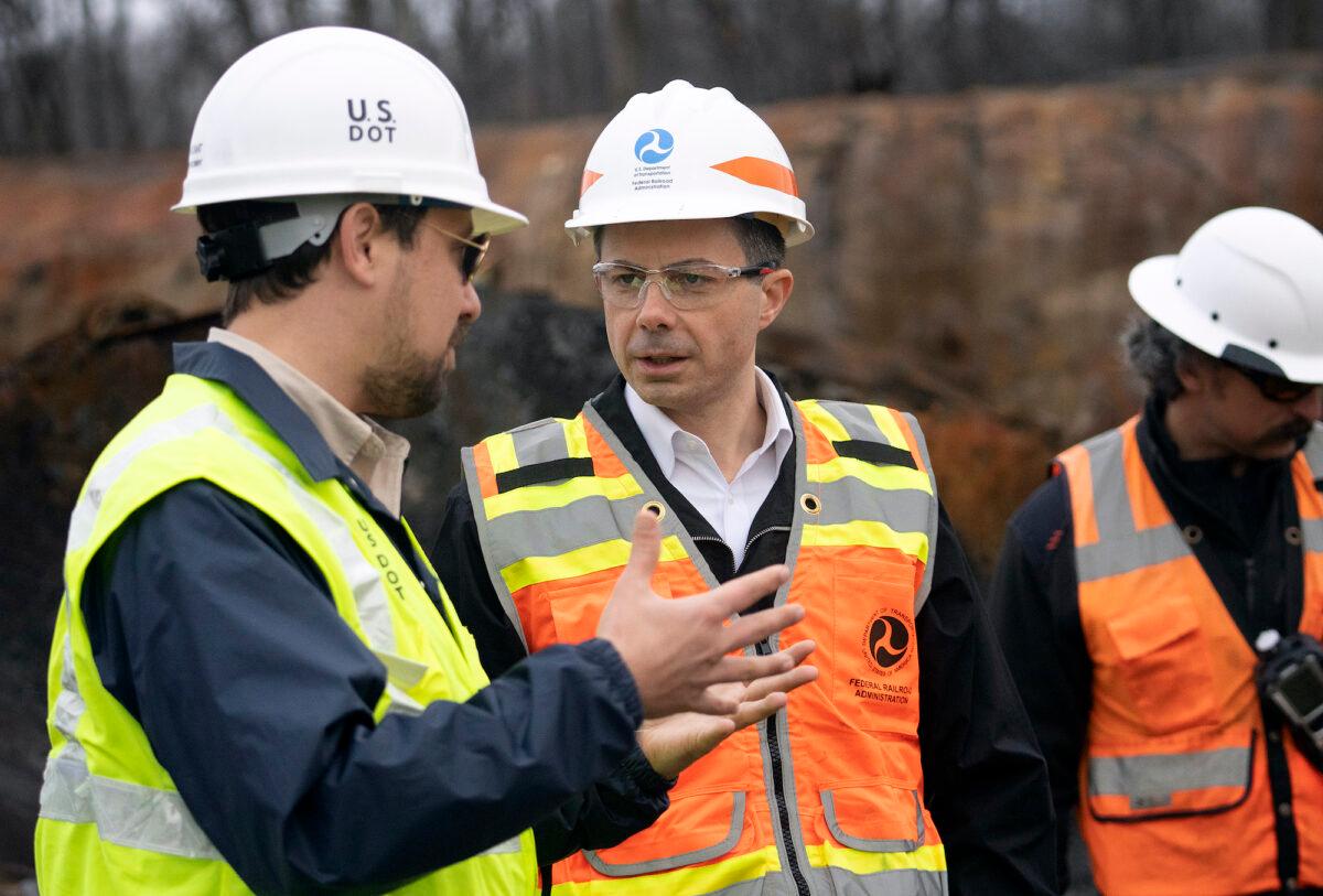 Secretary of Transportation Pete Buttigieg (C) visits with Department of Transportation investigators at the site of a derailment in East Palestine, Ohio, on Feb. 23, 2023. (Brooke LaValley-Pool/Getty Images)