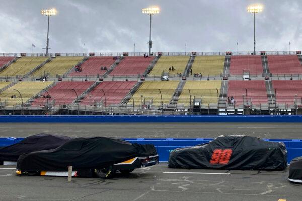 Covered race cars from the NASCAR Xfinity Series sit parked on pit road during a rain delay before the start of the race in Fontana, Calif., on Feb. 25, 2023. (Greg Beacham/AP Photo)