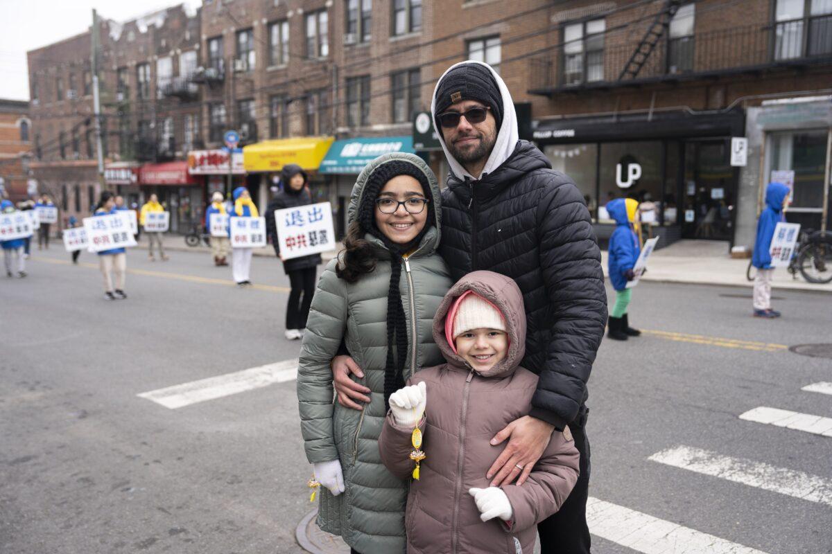 Miguel Garcia and his family watch Falun Gong practitioners march in a parade, in Brooklyn, N.Y., highlighting the persecution of their faith in China, on Feb. 26, 2023. (Chung I Ho/The Epoch Times)