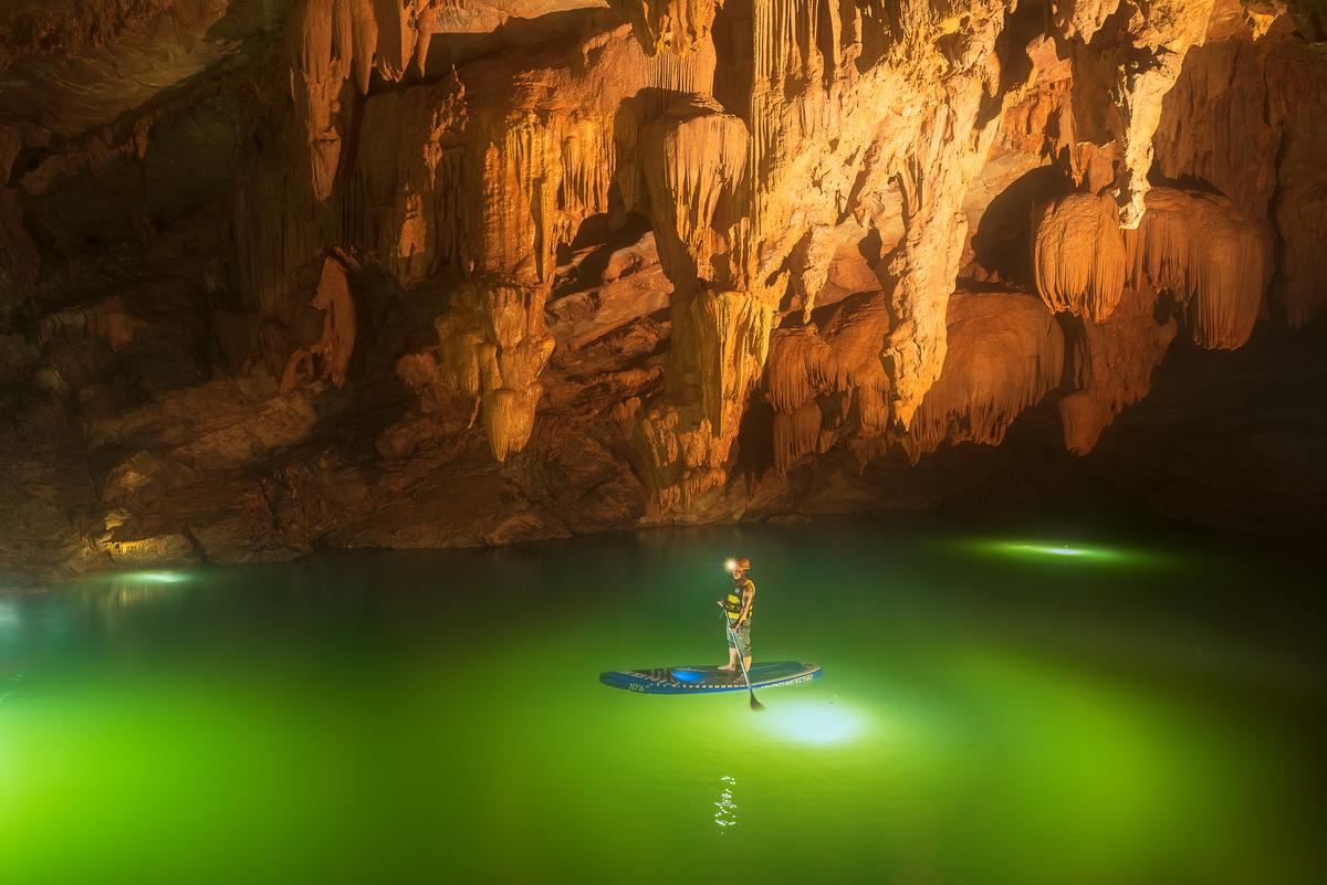 A paddleboarder in an underground lake in Tron Cave. (Courtesy of Tran Linh via Jungle Boss Tours)