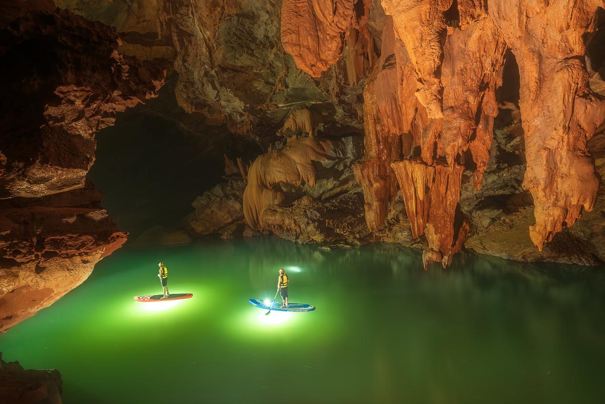 Paddleboarders explore Tron Cave's lake. (Courtesy of Tran Linh via Jungle Boss Tours)